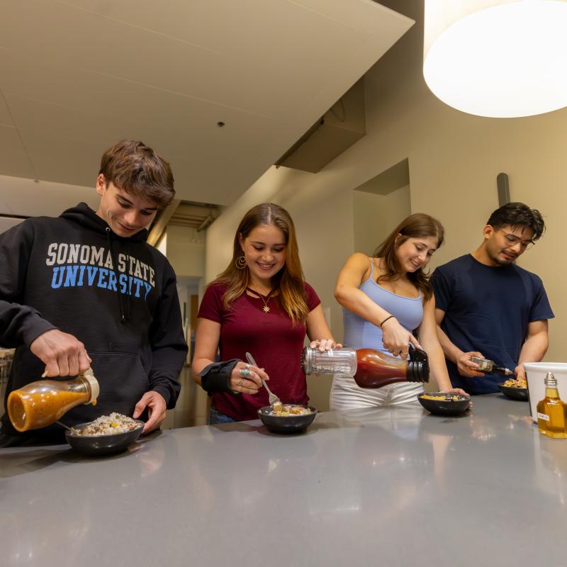 Four students grabbing food in the dining hall